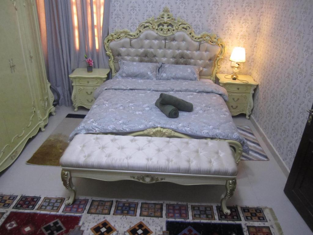 a bedroom with a king sized bed with a white mattress at العين الهيلي مصباح بيت 13 in Al Ain