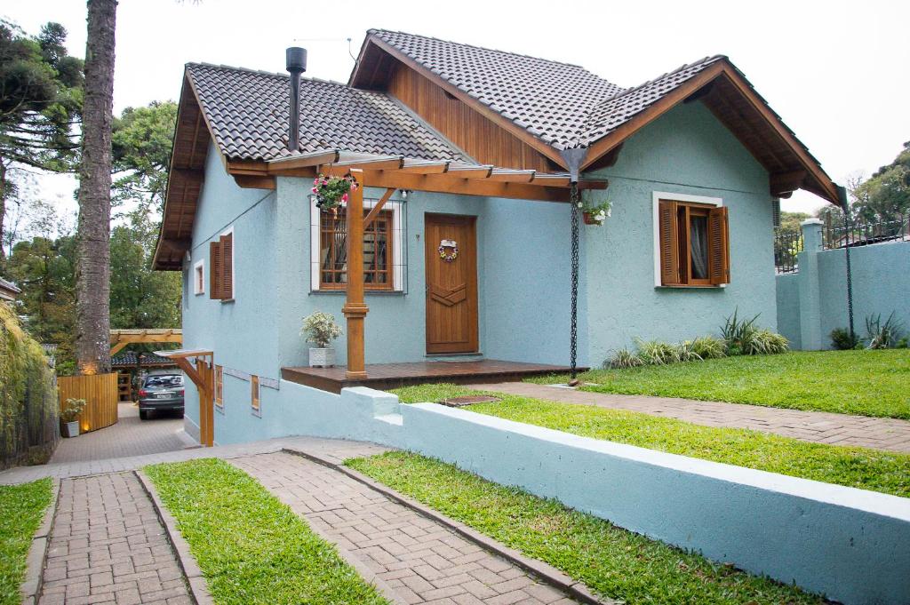 a small blue house with a brown door at Morada Bem Me Quer in Canela