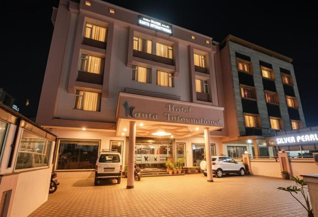 a building with a parking lot in front of it at Kanta International near katra railway station in Katra