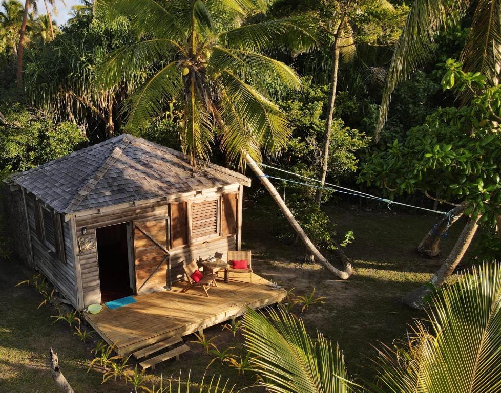a small house with a porch and palm trees at Fanifo Lofa in Ha’apai