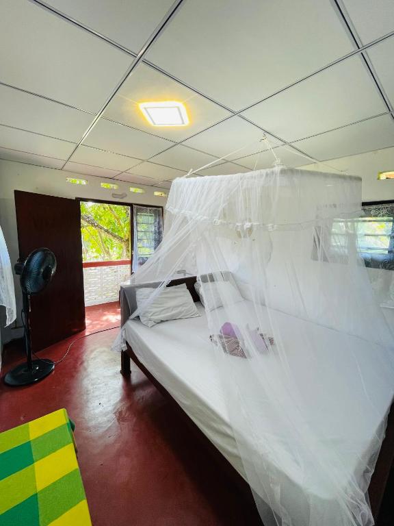 a bedroom with a bed with white mosquito net at Siri Niwasa Sky Villa in Ahangama
