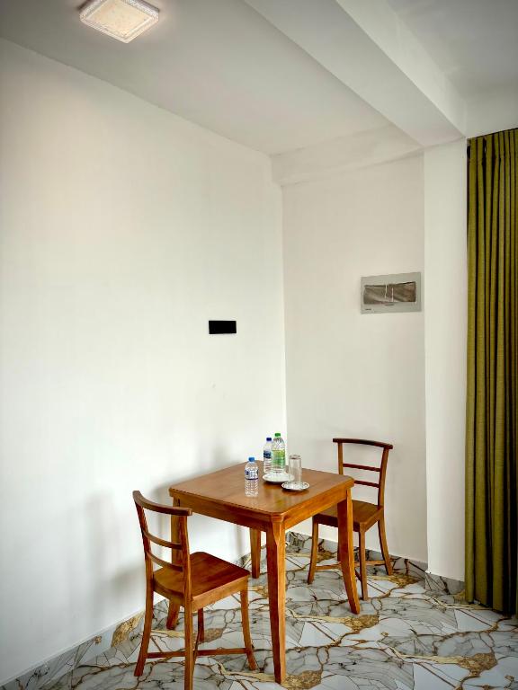 a dining room with a wooden table and two chairs at Sandaruwan villa in Ratgama Hegoda