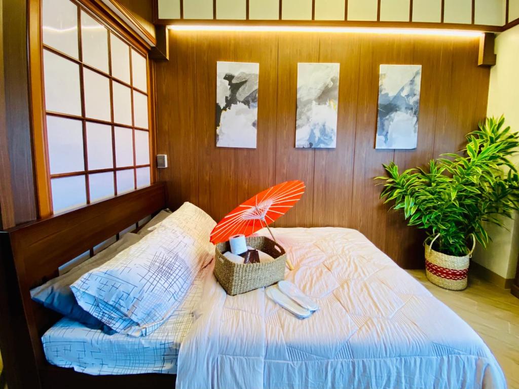 a bedroom with a bed with an umbrella on it at Okaeri Place - One Regis in Bacolod