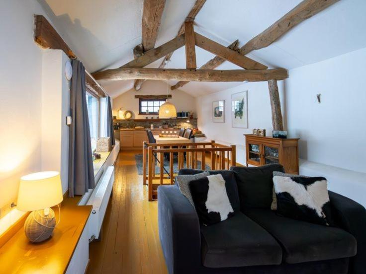 a living room with a couch and a dining room at Gîte de la chapelle in Houffalize