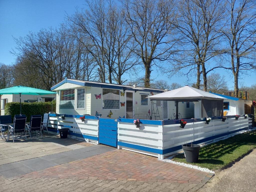 a blue and white mobile home with a patio at stacaravan nr16 is 5 persoons in Schoonloo