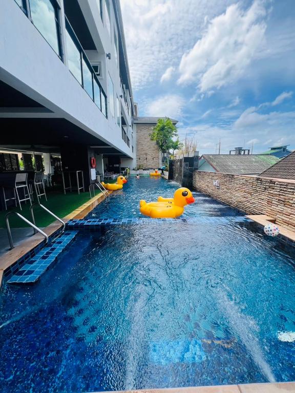 a swimming pool with inflatable ducks in a building at Baramee Resortel in Patong Beach