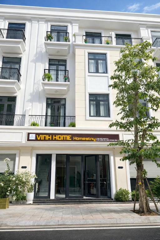 a white building with a sign that reads with hotel at Vinh Home Apartment in Quang Tri