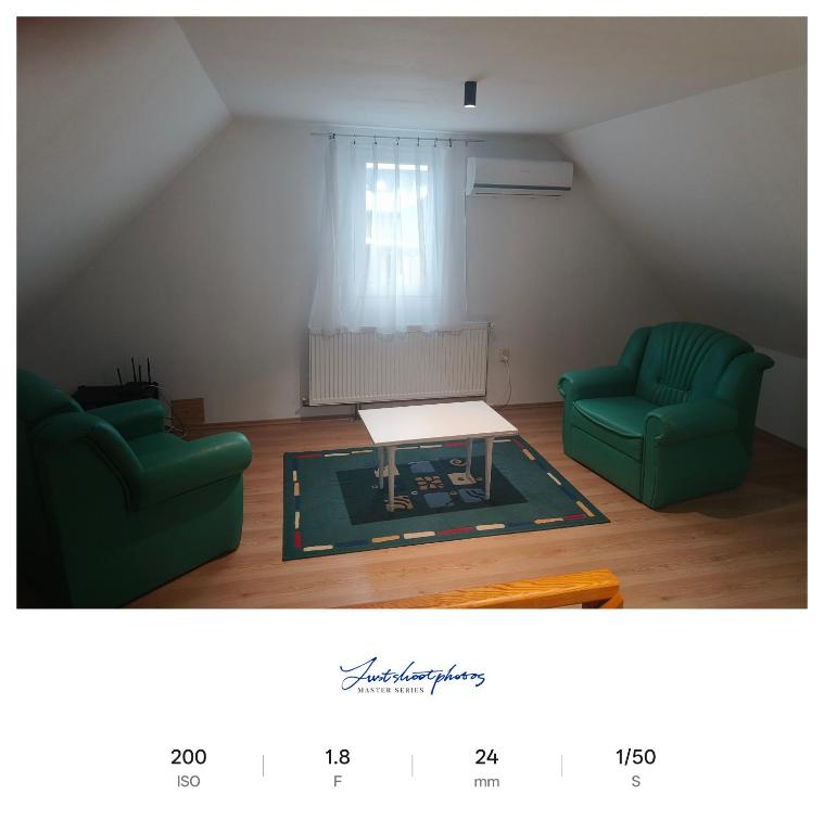 a living room with two green chairs and a coffee table at Apartament excepțional la casa in Dumbrăviţa