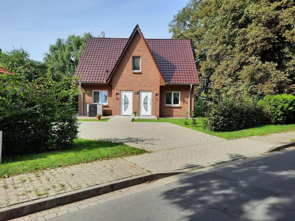 a brick house with a red roof and a driveway at Haus-Hempel-1 in Groß Mohrdorf