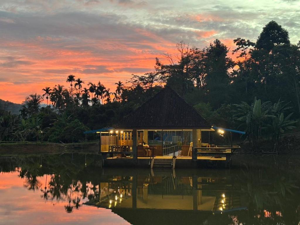 a small hut on the water at sunset at mist valley in Ban Nong Chaeng