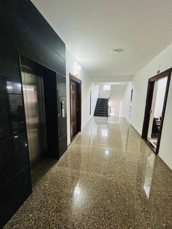 an empty hallway with black and white walls and a staircase at Mangalore serviced flats in Mangalore