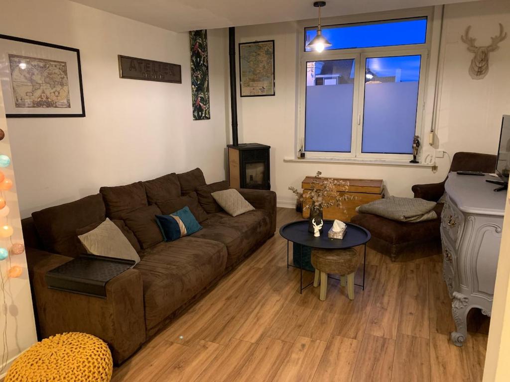 a living room with a couch and a table at Maison cocooning in Hazebrouck