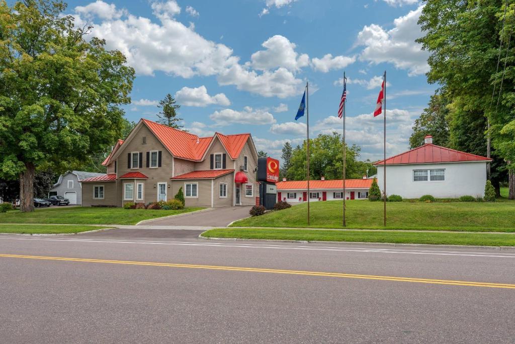 a house with two flags on the side of a street at Econo Lodge Saint Albans in Saint Albans