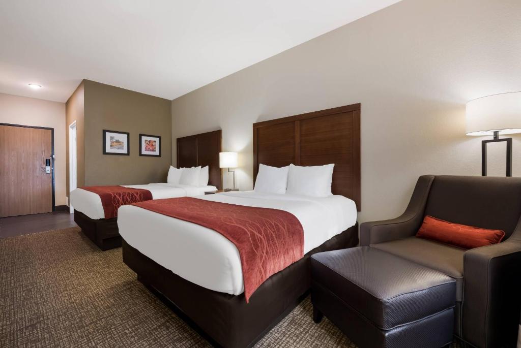 a hotel room with two beds and a chair at Comfort Inn Onalaska - La Crosse Area in Onalaska