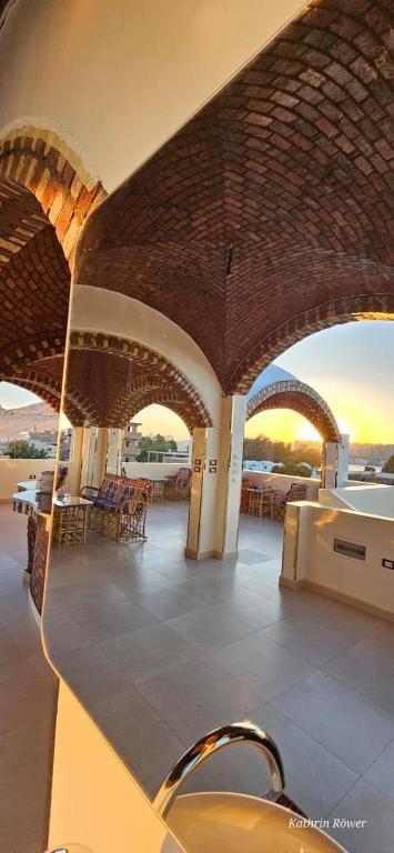 a building with a balcony with tables and chairs at Habibi Nubian Guest House-Nubian Hospitality in Aswan