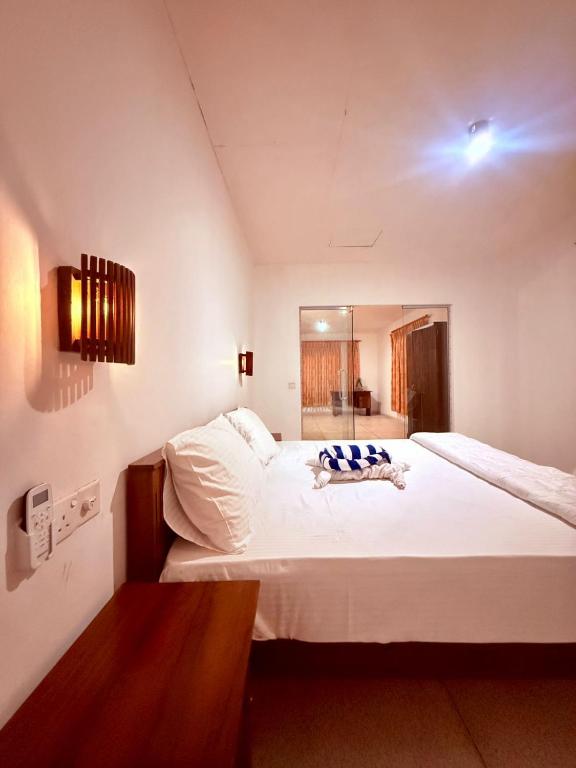 a bedroom with a large white bed in a room at The Kasbo in Unawatuna