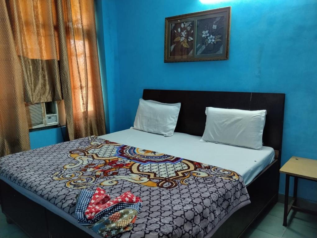ein Schlafzimmer mit einem Bett und einer blauen Wand in der Unterkunft Hotel The Height in Chandīgarh