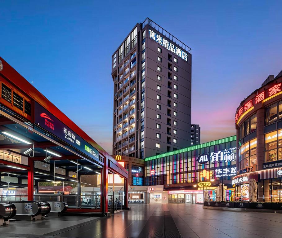 a large building in a city at night at RoomMe HOTEL寓洣公寓佛山铂顿祖庙岭南天地店 in Foshan