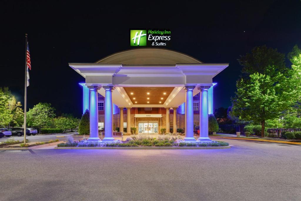 a building with a lit up sign at night at Holiday Inn Express & Suites Williamsburg by IHG in Williamsburg