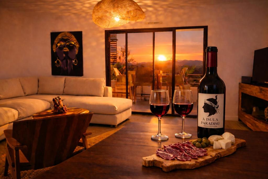 a living room with a bottle of wine and two glasses at A Isula Paradisu - Classé 4 étoiles in LʼÎle-Rousse