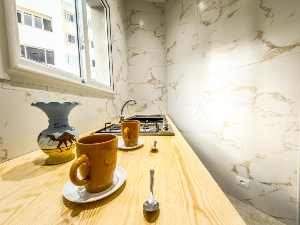 two coffee cups sitting on a counter in a kitchen at Lafayette Central Apartment-Tunis in Tunis