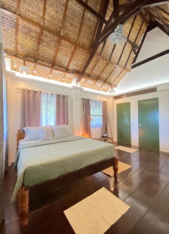 a bedroom with a bed in a room with windows at The Kokomo Siargao in General Luna