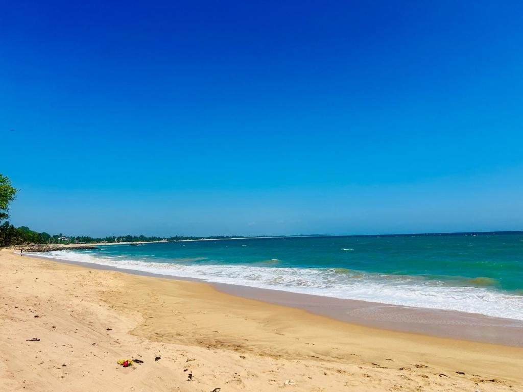 a sandy beach with the ocean in the background at Velora Villa Tangalle in Tangalle