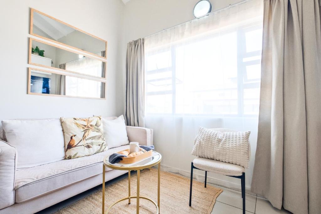 a living room with a couch and a chair at SoftPod Loft in Prime Location Fourways in Sandton