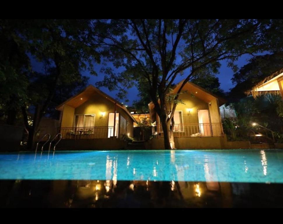 a house at night with a swimming pool at Cape Nirvana, Backwater & Pool villa in Lavasa