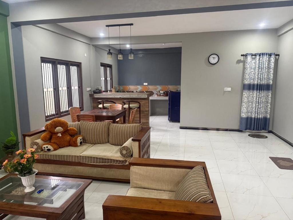 a living room with a teddy bear sitting on a couch at Palm Breeze Kokuvil G1 in Jaffna
