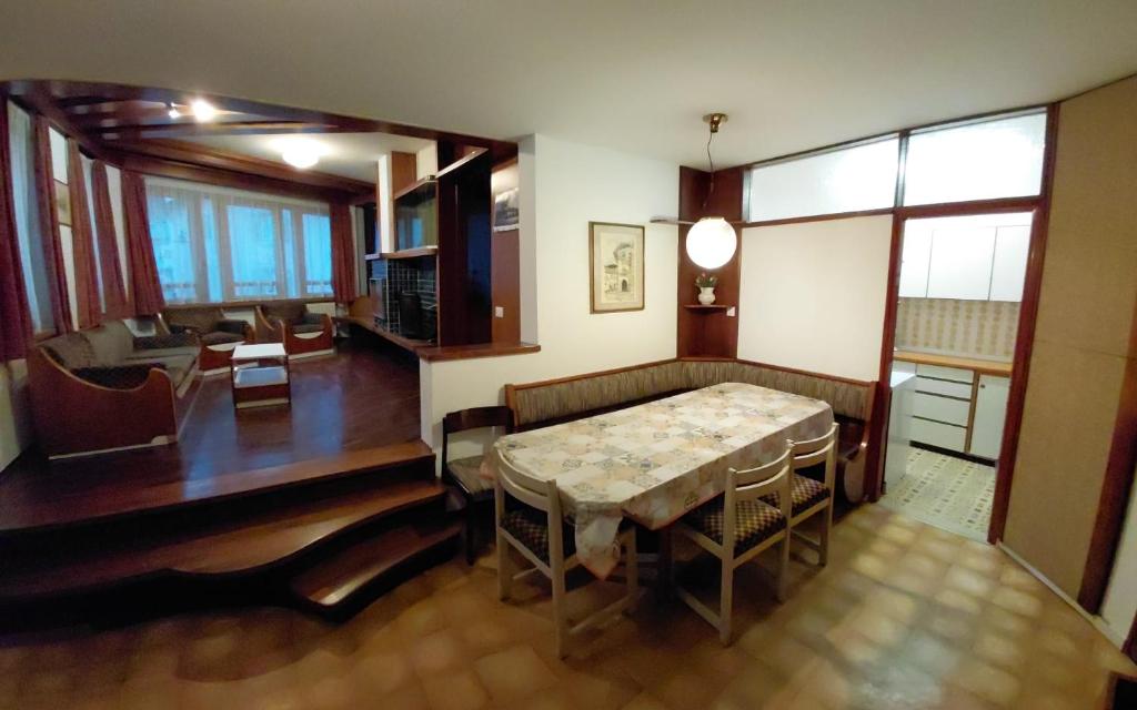a living room with a table and a dining room at Appartamento IN CENTRO a Predazzo in Predazzo
