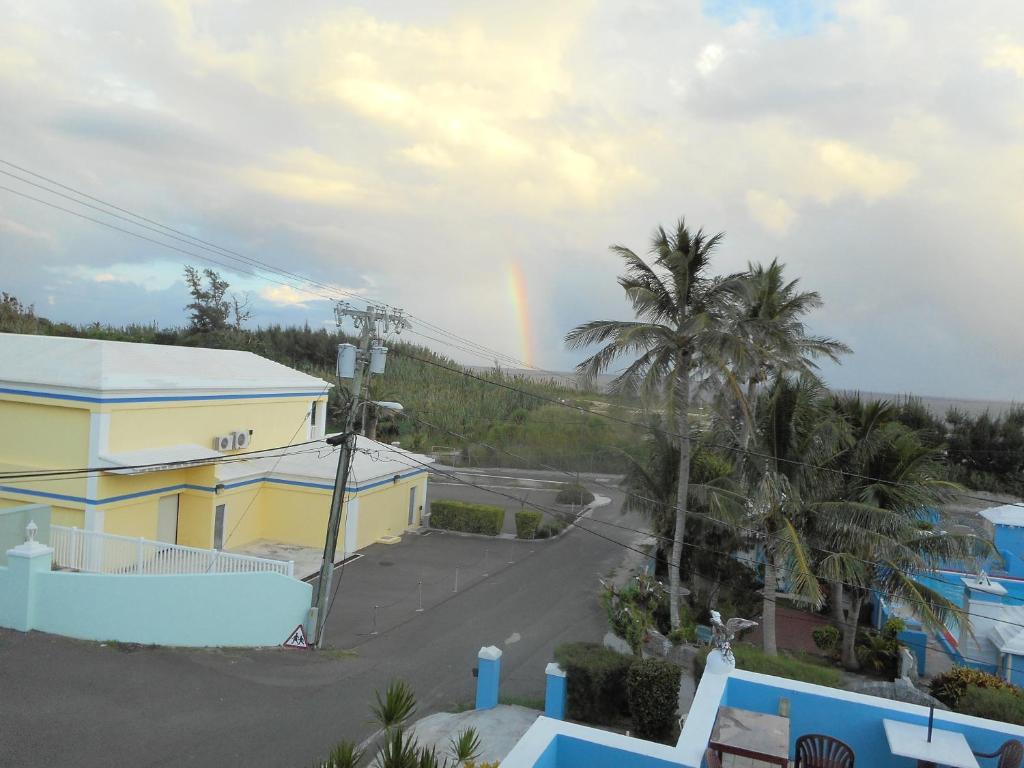 um arco-íris no céu sobre uma rua com casas em Blue Horizons Guest House em Hamilton