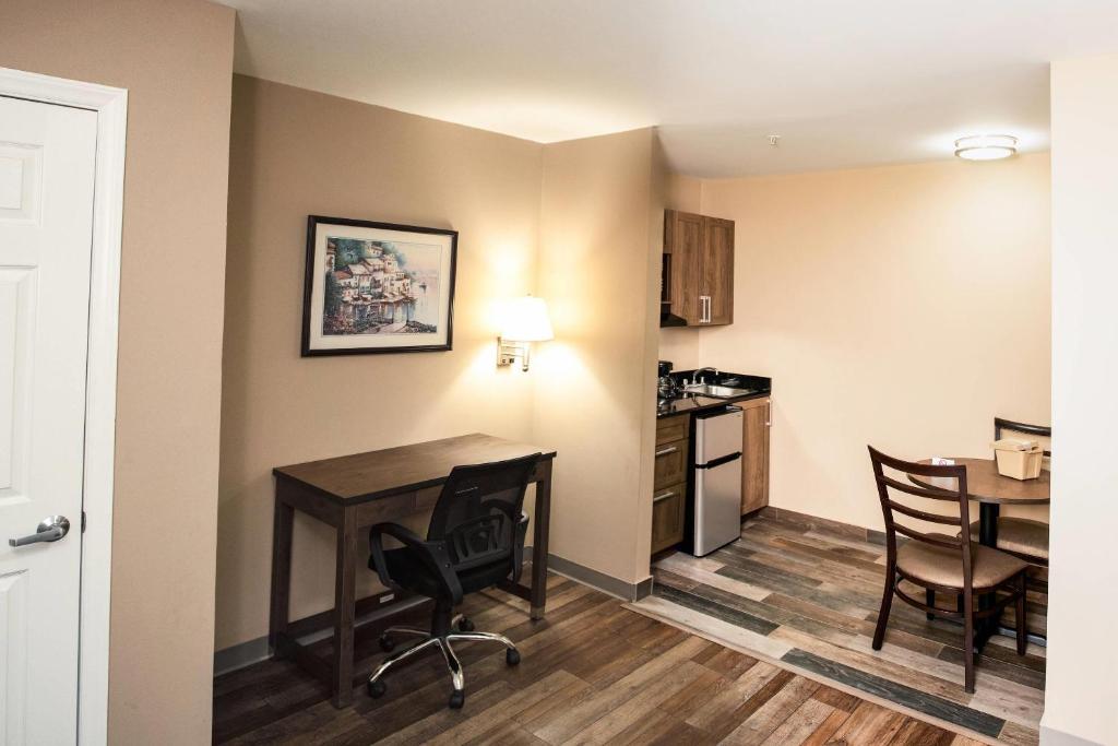 a kitchen and dining room with a table and chairs at Suburban Studios Charlotte - Ballantyne in Charlotte