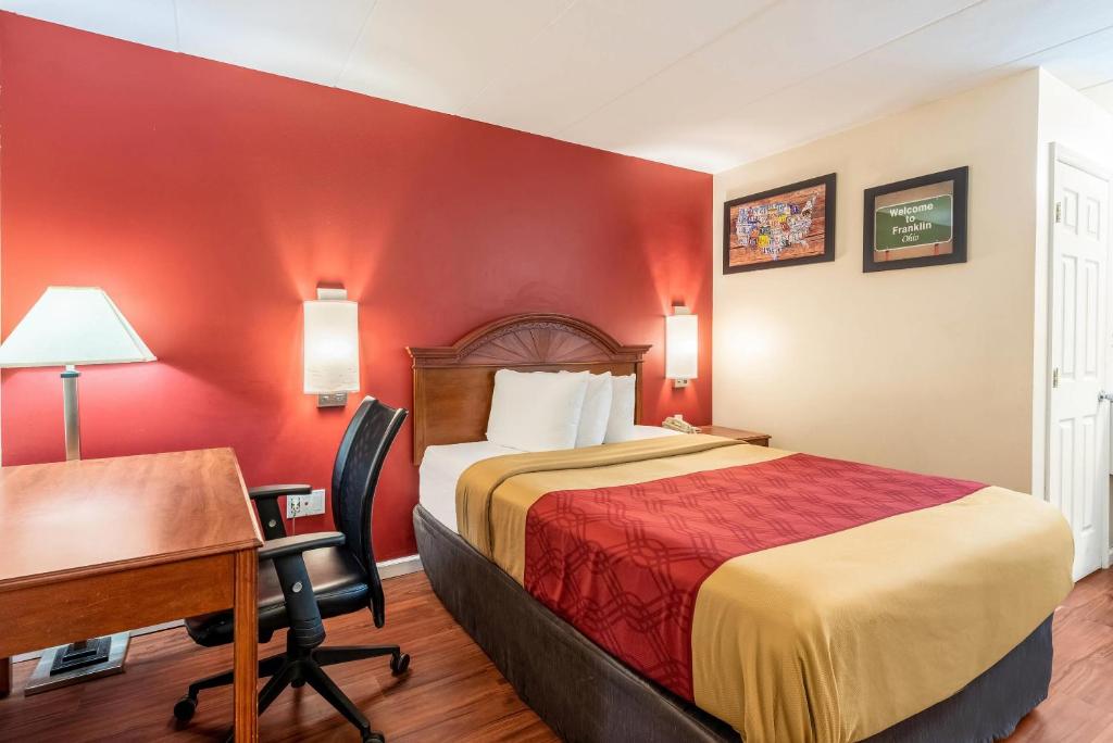 a hotel room with a bed and a desk at Econo Lodge Franklin - Springboro in Franklin