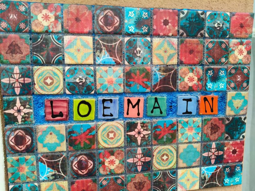a mosaic tile wall with the wordulum written on it at Loema-in in Roodepoort