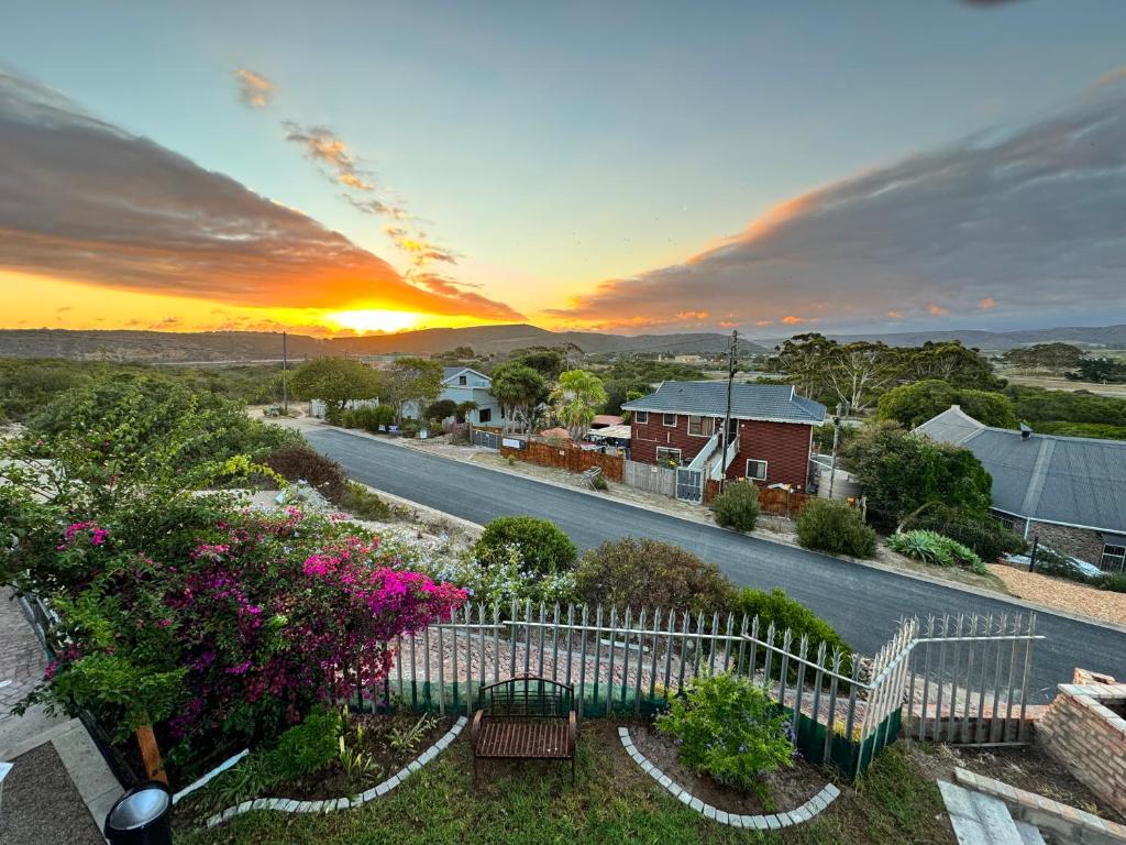 a view of a street with a fence and flowers at Fraai Brak in Klein-Brakrivier