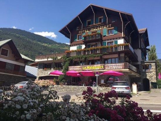 a large building with pink umbrellas in front of it at hotel le malgovert SEEZ 73 in Séez