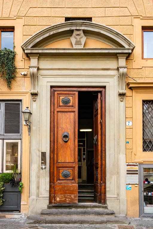 a large wooden door in a building with stairs at Lumi Stays in Florence