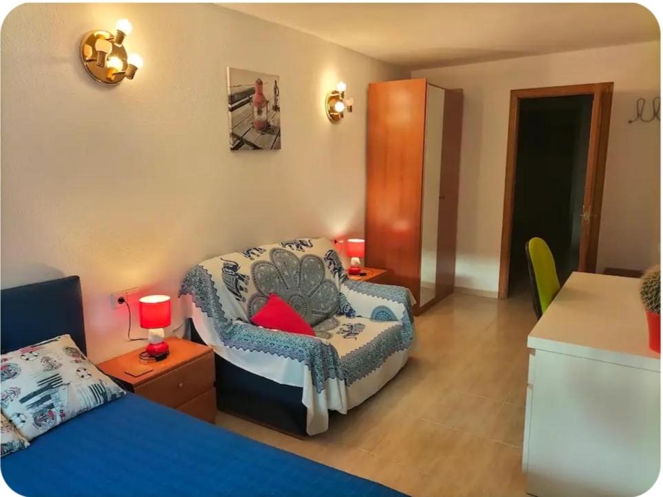a room with a bed and a couch and a chair at Habitación individual en la playa in Alicante