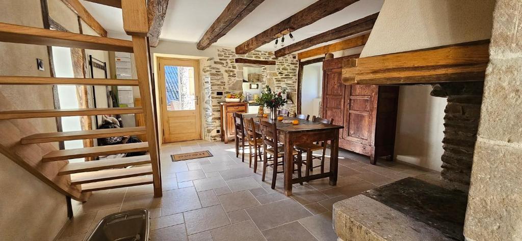 a kitchen with a table and a stone fireplace at Oustal de Piarelle in Saint-Jean-du-Bruel