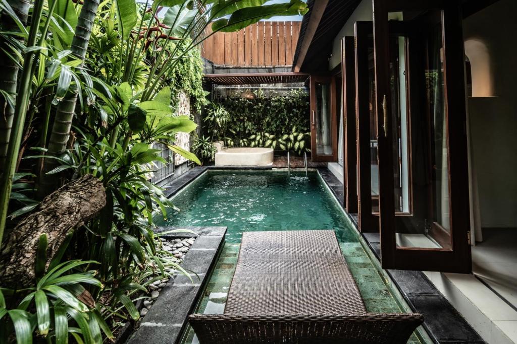 a pool in the middle of a house with plants at Seminyak Sanctuary Villa by Ini Vie Hospitality in Seminyak