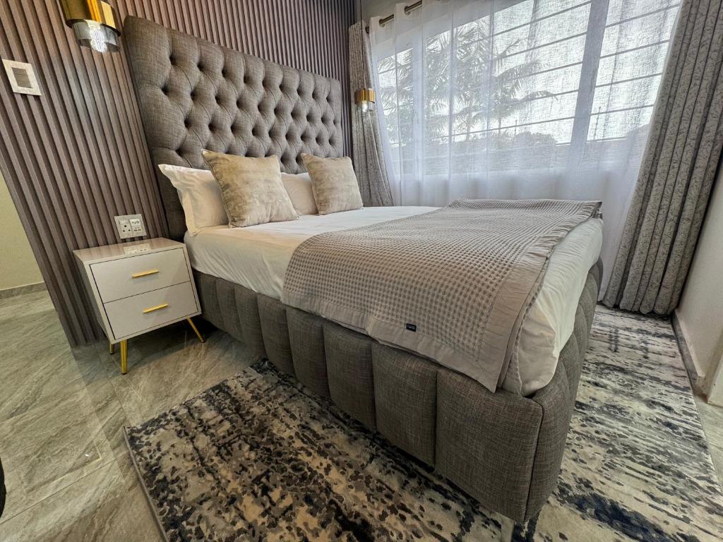 a bedroom with a large bed with a large window at G - Boutique in Durban