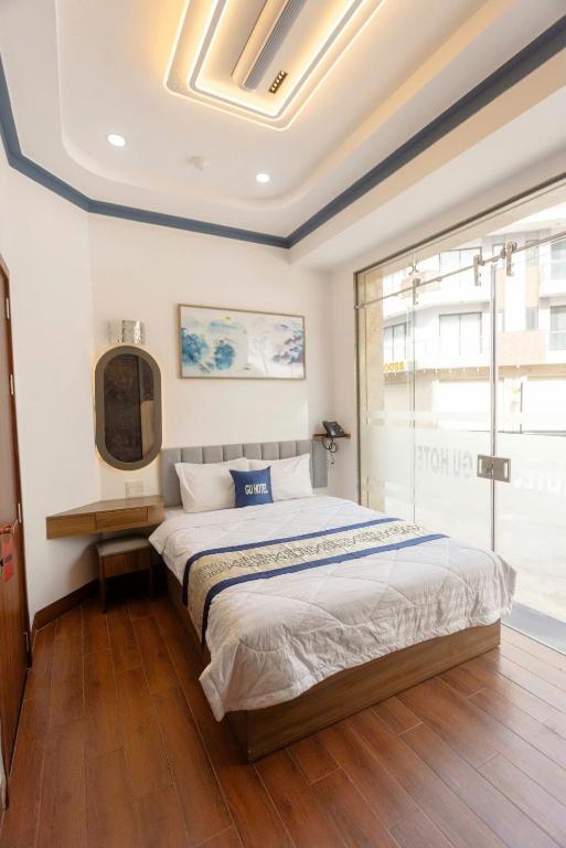a bedroom with a large bed and a window at Gu Boutique Hotel - Central Phan Rang in Phan Rang–Tháp Chàm