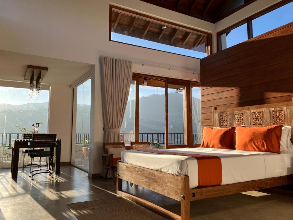 a bedroom with a bed and a desk and windows at SereneVbes - Kandy in Kandy