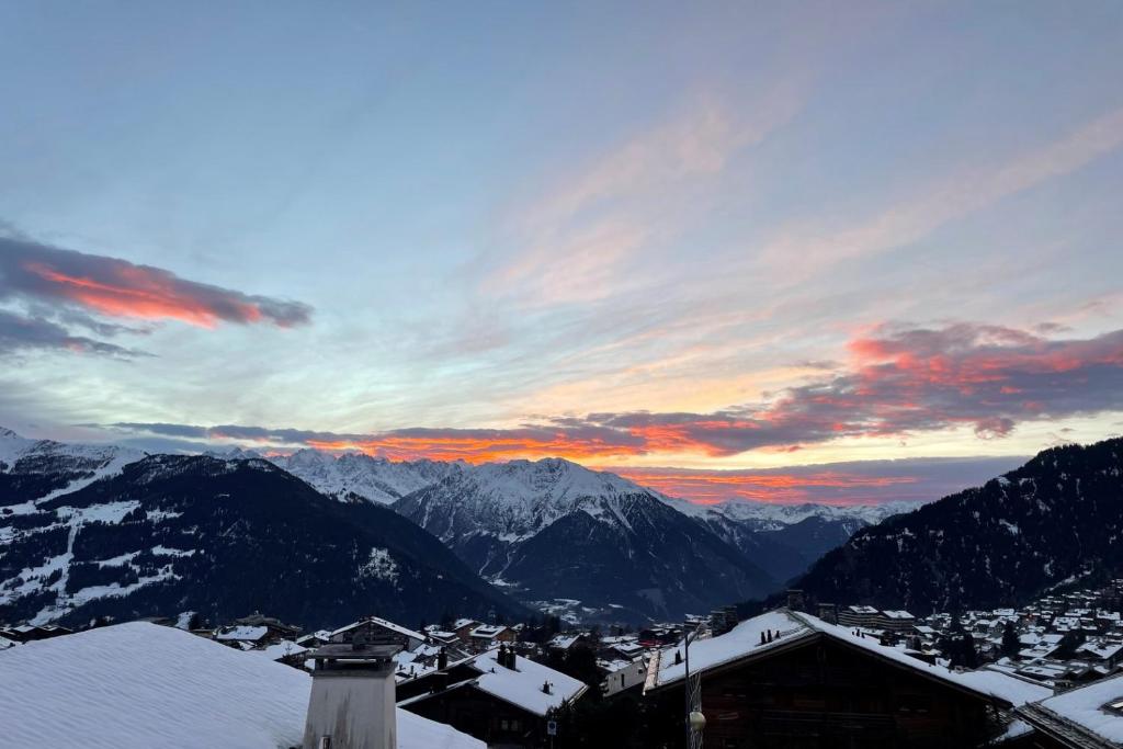 a view of a snowy mountain range with a sunset at Roxes 6, duplex cosy et lumineux à proximité de Médran in Verbier