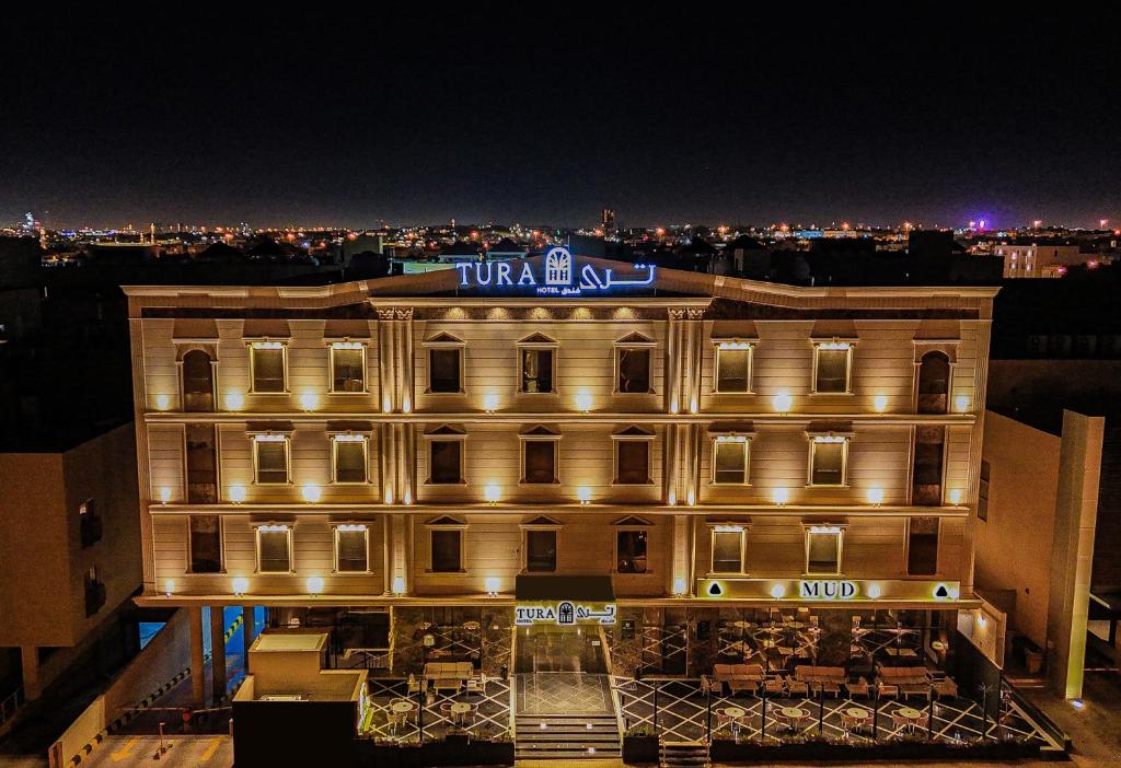 a building with a sign on top of it at night at فندق ترى النزهة -Tura Hotel AlNuzha in Riyadh