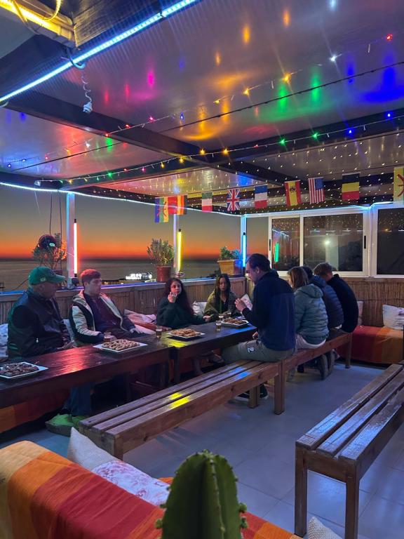 a group of people sitting at tables in a restaurant at Ami d'or Hostel in Taghazout