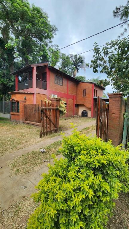 a house with a fence in front of it at Casa Rivadavia en El Paso in Paso de la Patria