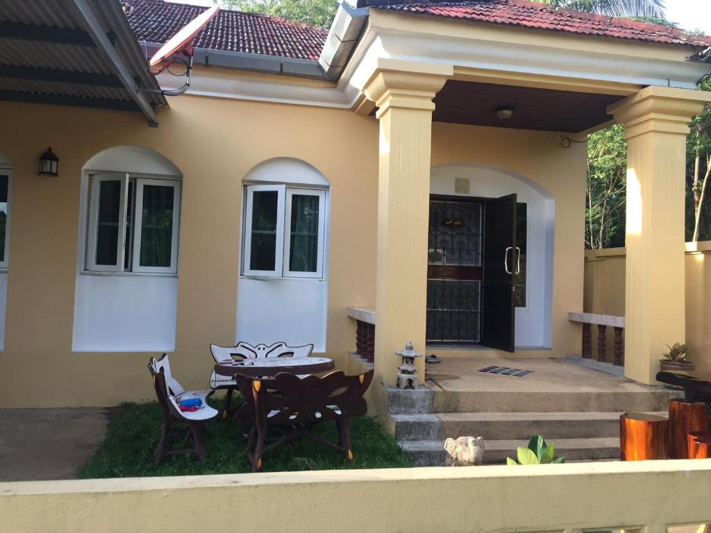 a house with a table and chairs in front of it at Good Villa by Saran in Krabi