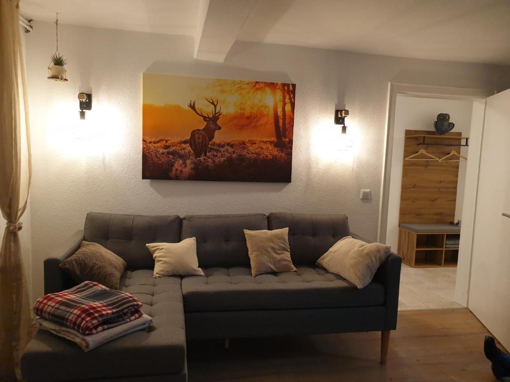 a living room with a couch and a painting on the wall at Ferienwohnung zur Honigschleife in Langweiler